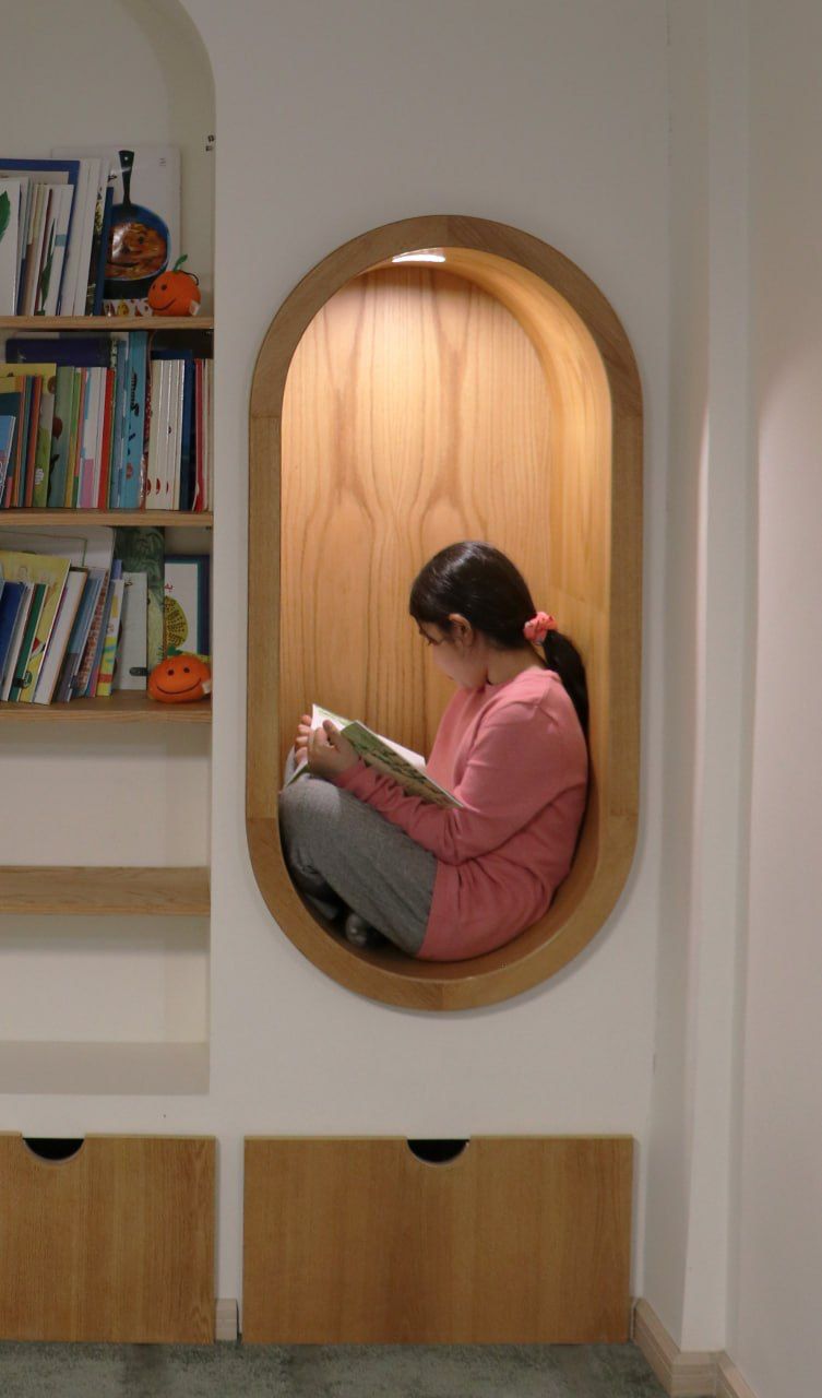 A child reading in a low oval alcove