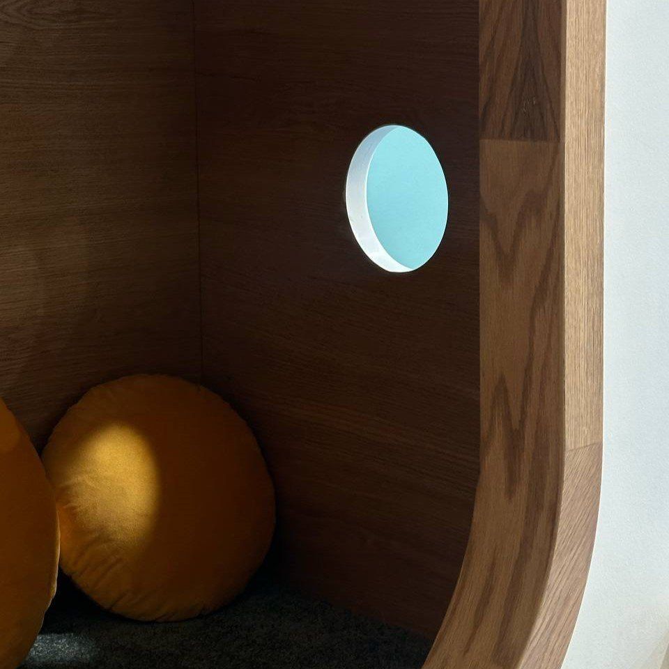 A wooden nook with a round window